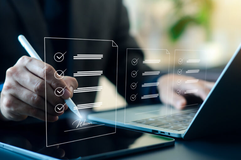 Business professional signing digital checklist and electronic document on tablet with laptop. Online approval, e-signature, workflow management, compliance audit and paperless business process.